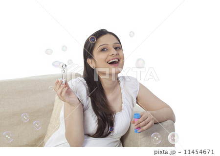 Woman blowing soap bubbles Woman blowing soap bubbles 11454671