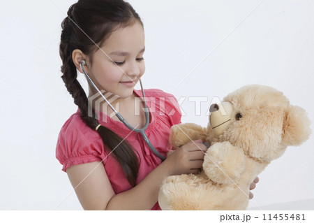 Little girl playing doctor with a teddy bear 11455481