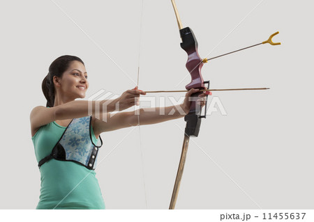 Young woman practicing archery isolated over gray background 11455637