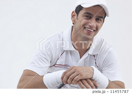 Portrait of happy male tennis player with racket isolated over gray background 11455787