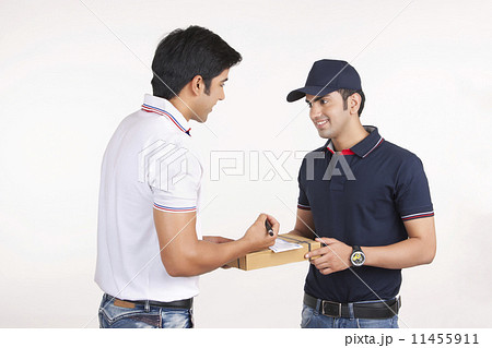 Smiling delivery man delivering package to customer against white background 11455911