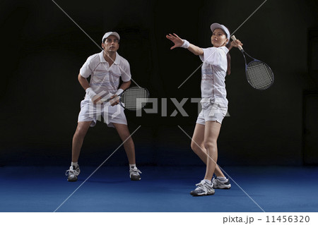 Male and female players playing tennis doubles at court Male and female players playing tennis doubles at court 11456320