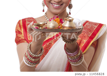 Close-up of Bengali woman's hands holding puja thali 11456828