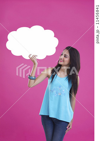 Happy young woman holding thought bubble over pink background 11456841