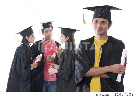 Portrait of confident graduate student with friends discussing against white background Portrait of confident graduate student with friends discussing against white background 11457008