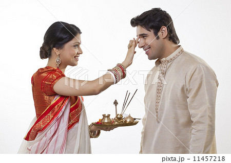 Bengali woman putting tika on man's head 11457218
