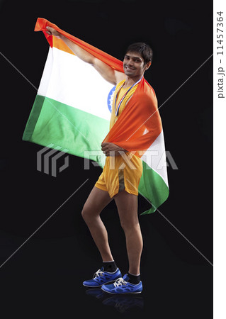 Full length portrait of happy male medalist with Indian flag against black background Full length portrait of happy male medalist with Indian flag against black background 11457364