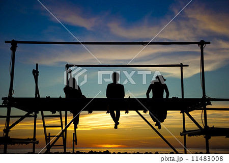 夕日を背にした逆光の3人 青春イメージ 新島の写真素材