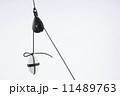 White stone, tied with dark rope, suspended with the use of a pulley.  11489763