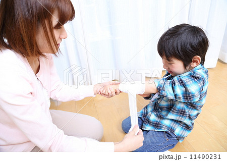 腕に包帯を巻いてもらう男の子 11490231