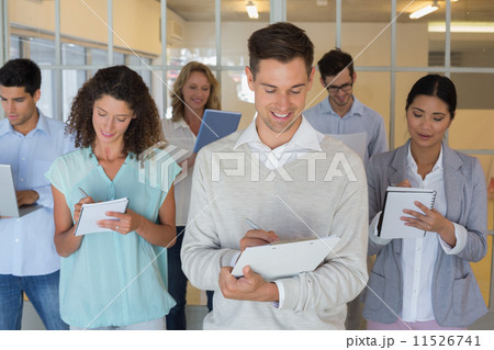 Casual boss standing in front of his team all taking notes 11526741