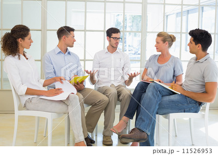 Casual business team sitting in a circle having a meeting 11526953
