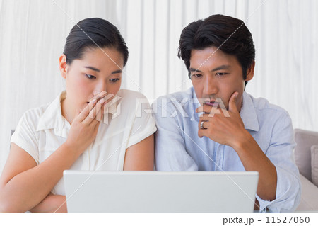 Worried couple using laptop together 11527060