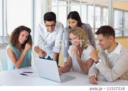 Casual smiling business team having a meeting using laptop 11527216