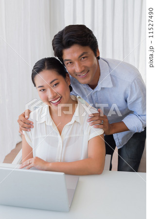 Happy couple using laptop together Happy couple using laptop together 11527490