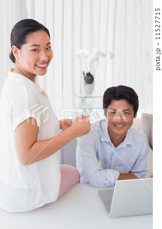 Happy couple using laptop together 11527715