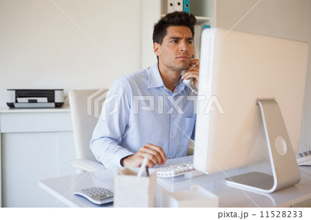 Casual businessman on the telephone at desk Casual businessman on the telephone at desk 11528233