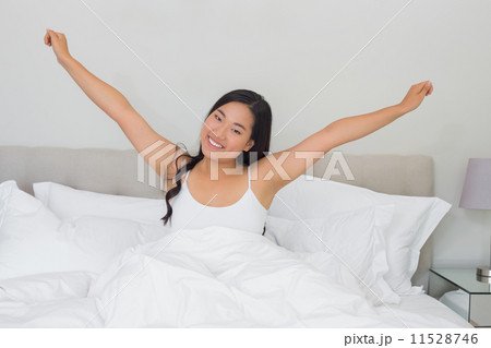 Smiling woman stretching in bed in the morning 11528746
