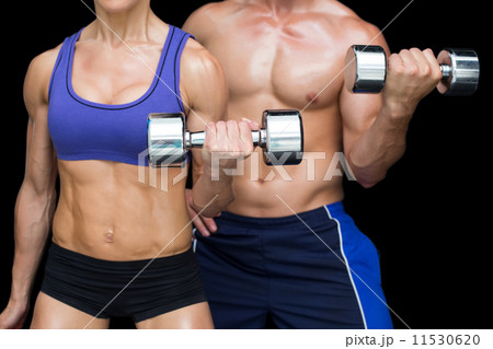 Bodybuilding couple posing with large dumbells 11530620