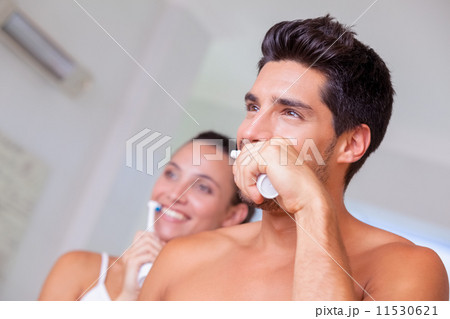 Attractive couple brushing their teeth in the morning 11530621