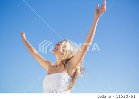 Woman in white dress standing with arms outstretched Woman in white dress standing with arms outstretched 11530761