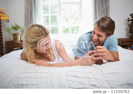 Cute couple relaxing on bed laughing together Cute couple relaxing on bed laughing together 11530762