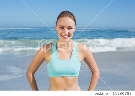 Fit woman standing on the beach with hands on hips Fit woman standing on the beach with hands on hips 11530782