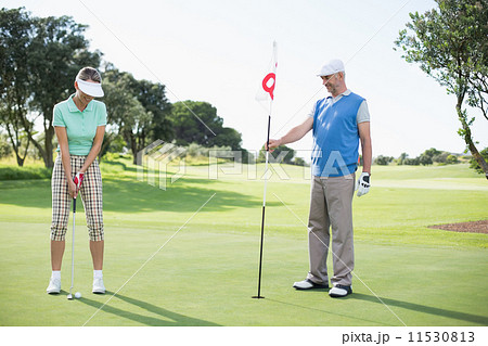 Golfing couple at the eighteenth hole on the golf course 11530813