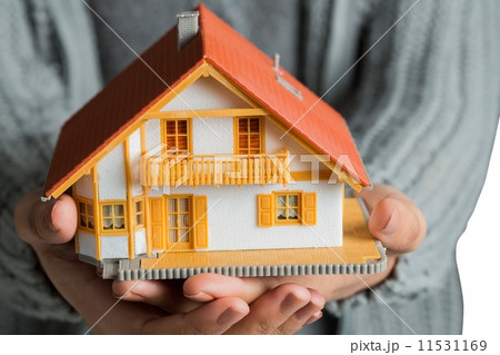 Hands showing a miniature model home 11531169