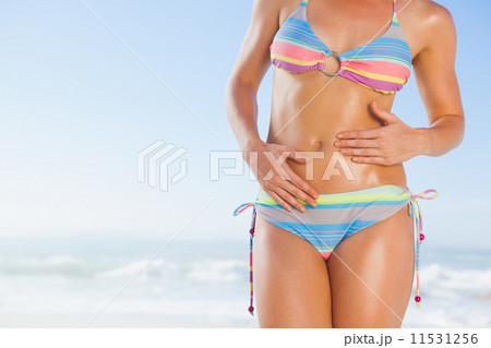 Mid section of fit woman in bikini on the beach 11531256
