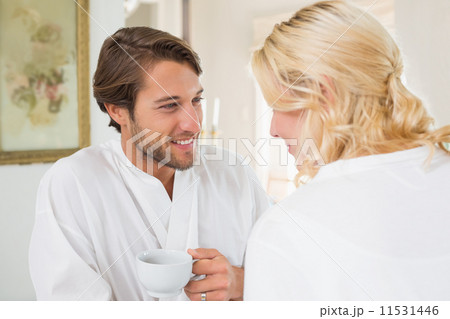 Cute couple in bathrobes having coffee together 11531446