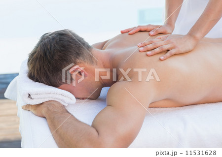 Handsome man getting a massage poolside Handsome man getting a massage poolside 11531628