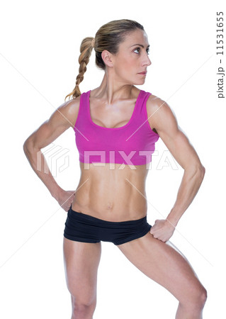 Female bodybuilder posing in sports bra and shorts Female bodybuilder posing in sports bra and shorts 11531655