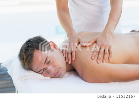 Handsome man getting a massage poolside 11532167