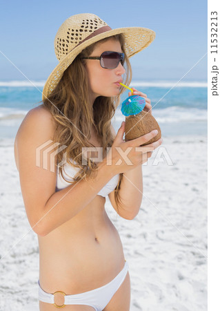Pretty blonde in white bikini drinking coconut drink on the beac Pretty blonde in white bikini drinking coconut drink on the beac 11532213