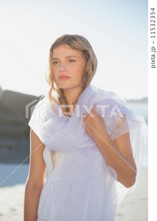 Beautiful blonde in white sundress and scarf on the beach Beautiful blonde in white sundress and scarf on the beach 11532354