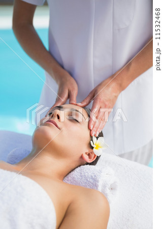 Tranquil brunette getting a head massage poolside Tranquil brunette getting a head massage poolside 11532468