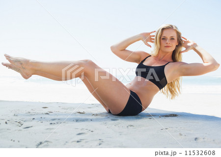 Fit blonde in core balance pilates pose on the beach 11532608
