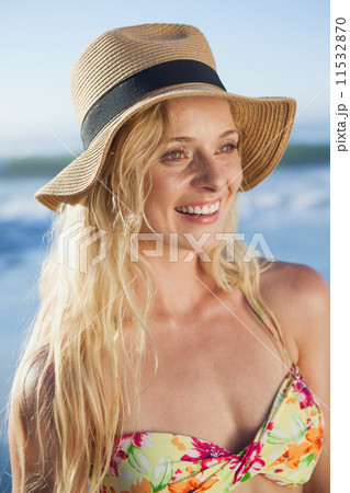 Gorgeous blonde in straw hat smiling on beach 11532870