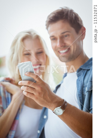Cute young couple looking at smartphone together 11532871