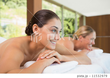 Smiling friends lying on massage tables 11532979