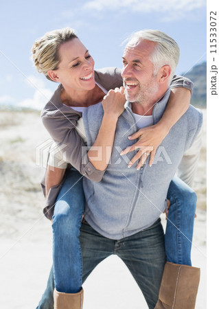 Laughing couple smiling at each other on the beach Laughing couple smiling at each other on the beach 11533072