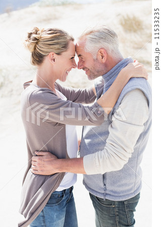 Happy hugging couple on the beach looking at each other 11533235
