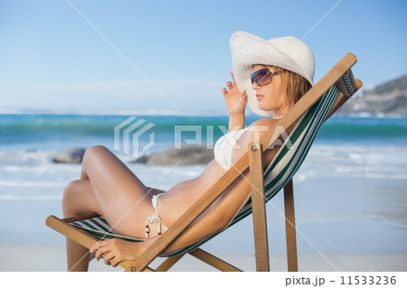 Pretty woman relaxing in deck chair on the beach 11533236