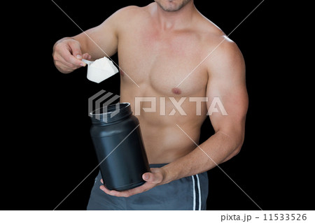 Muscular man scooping up protein powder 11533526