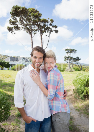 Smiling couple standing outside together in their garden 11533572