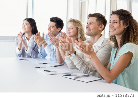 Casual business team clapping at presentation 11533573