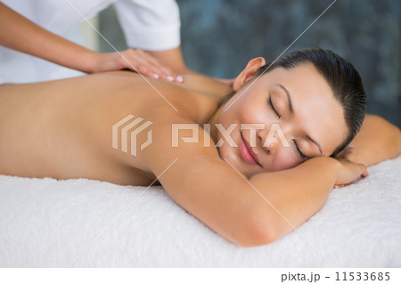 Smiling brunette enjoying a back massage Smiling brunette enjoying a back massage 11533685