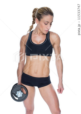 Female bodybuilder holding large black dumbbell with arm down Female bodybuilder holding large black dumbbell with arm down 11533747