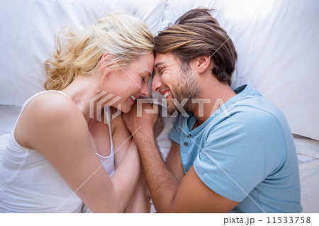 Cute couple relaxing on bed smiling at each other 11533758